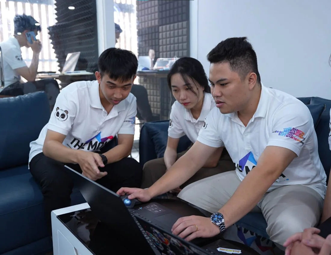 Ba nhân sự MONA ngồi cùng nhau trao đổi công việc bên laptop