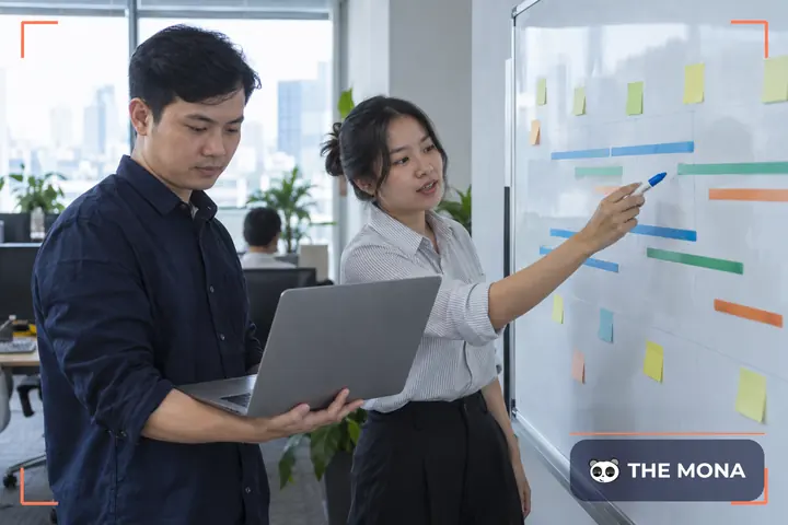 Hai kỹ sư phần mềm lập lịch nâng cấp trên bảng trắng có các thanh thời gian nhiều màu