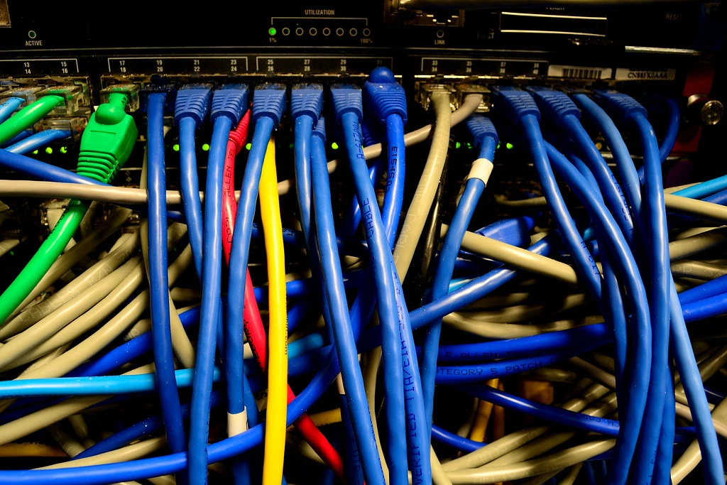 Cáp mạng nhiều màu nối vào cổng bảng điều khiển của thiết bị mạng trong tủ rack